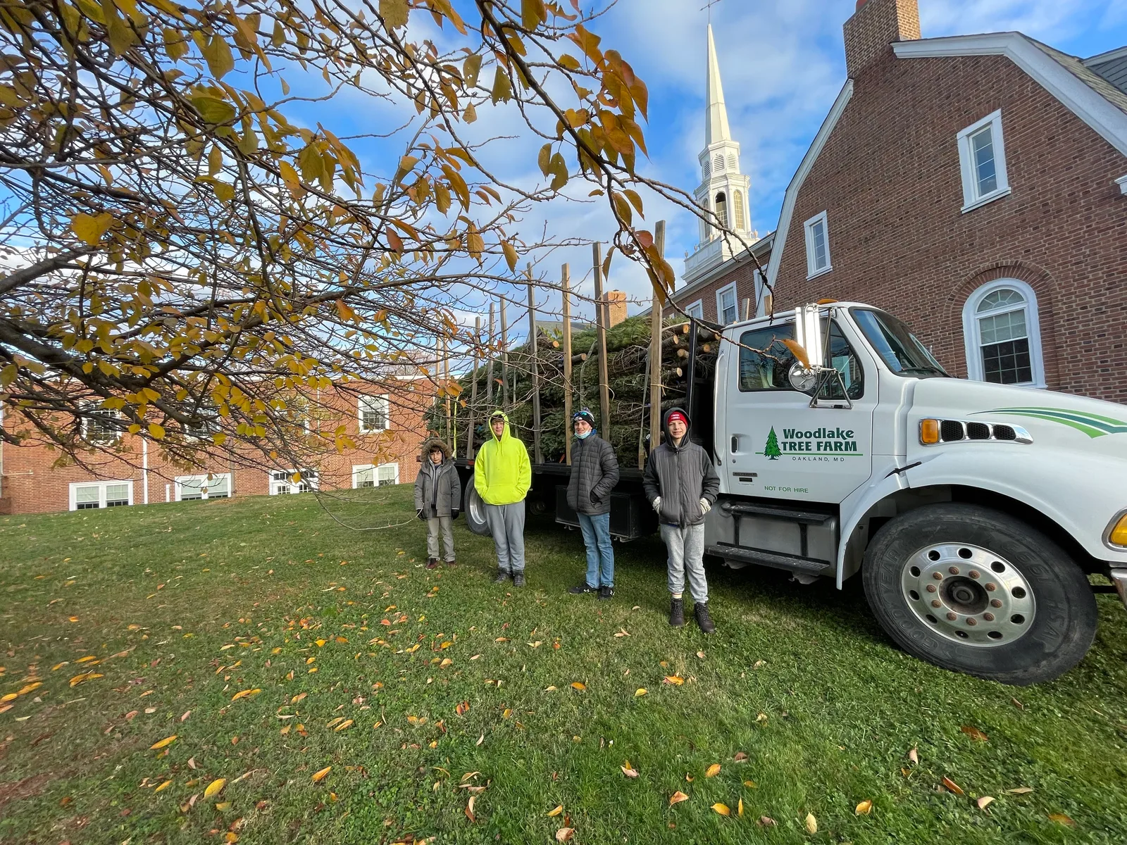 Scouts standing beside a truck loaded with Christmas trees in Catonsville